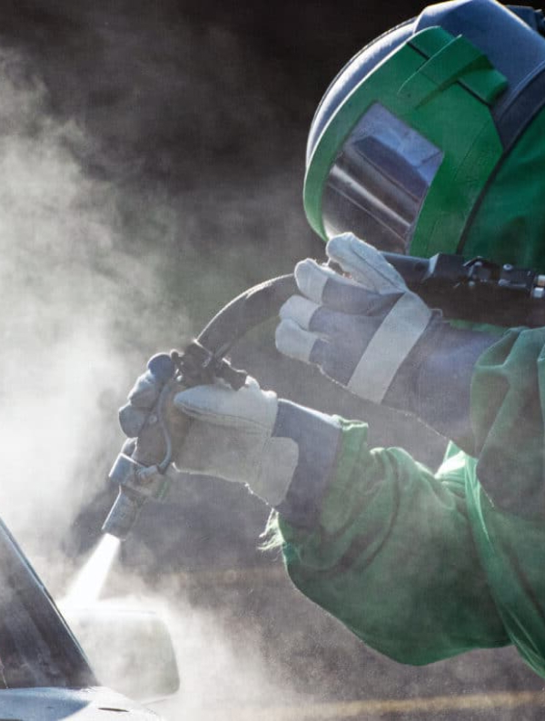 Equipo de sand blast utilizado por empleado, utilizando los equipos de seguridad necesarios para operar